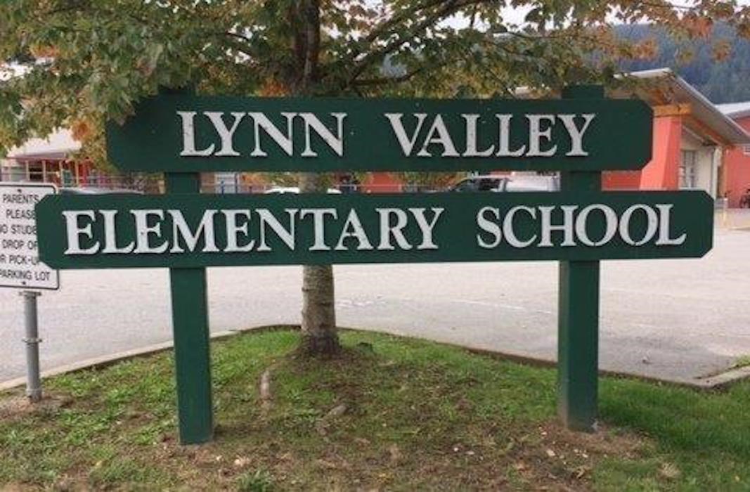 A photo of the Lynn Valley Elementary school sign. White writing on a green wooden background.